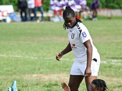 Arnett Gardens’ Shikira Douglas falls to the ground after scoring her fourth goal in a Jamaica Women’s Premier League encounter against Real Mona at the Alpha Institute on Saturday. Looking on is teammate Tasheka Reid.