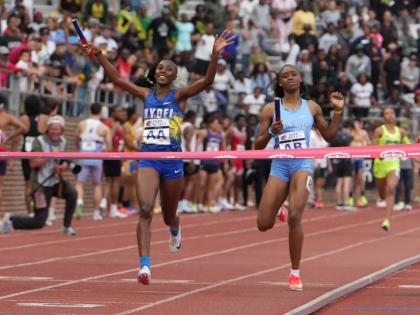 Hydel High’s Nastassia Fletcher (left) celebrates before crossing the finish line to seal her school’s fifth consecutive win in the Penn Relays Championship of America 4x400 metres in Philadelphia yesterday. At right is Edwin Allen High’s  Marria Cro