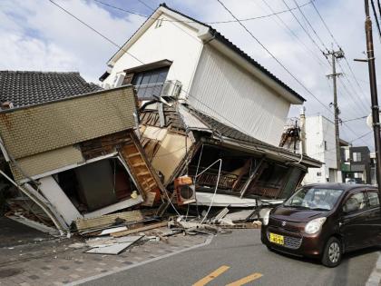 A vehicle passes by collapsed houses after an earthquake in Yatsushiro, Kumamoto prefecture in southwestern Japan on Wednesday. – AP photo