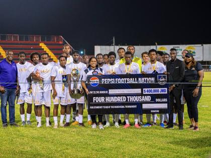 Pepsi Jamaica Brand Manager Ashli-Raye Recas (seventh from left) hands over a symbolic J$400,000 developmental cheque to members of the victorious JPL U-23 All-Star team, following the inaugural Made4Goal Championship Showcase at the Anthony Spaulding Spor