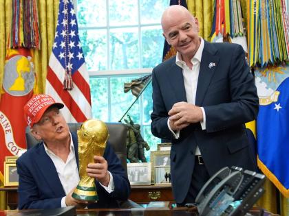 President Donald Trump holds the FIFA World Cup Winners’ Trophy as FIFA President Gianni Infantino looks on during an announcement in the Oval Office of the White House on August 22, 2025.