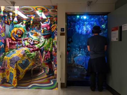 A visitor views an installation by Margüi while standing beside an installation by Guy “Dioz” Bloom during the “Hospital of Emotions” exhibition inside a former hospital building in Los Angeles.