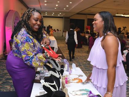 We Inspire Women exhibitor Shauna Kaye Whitter (left) of Kay Anne’s Kollection engages with Charissa Clemetson during the 2023 event. 