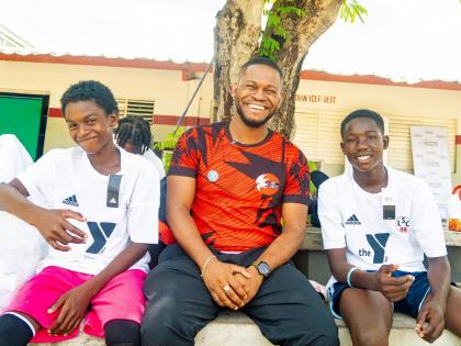 Grace & Staff Community Development Foundation Programme Manager Sujae Boswell (centre) shares a light moment with participants at the foundation’s recent Football Bonanza.