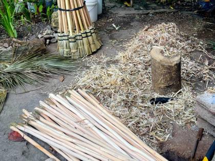 Prepared sticks, palm thatch and finished broom heads await assembly during the broom-making process.Prepared sticks, palm thatch and finished broom heads await assembly during the broom-making process.