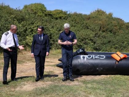 Britain’s Prime Minister Andy Burnham (centre) speaks with interim Chief Coastguard John Craig and Border Security Commander Duncan Capps beside a recovered migrant boat during a visit to HM Coastguard’s Maritime Rescue Coordination Centre in Dover, En