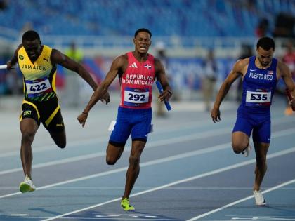 Dominican Republic’s Yancarlos Martinez (centre)  crosses the finish line to win the gold medal in the men’s 4x100-meter relay final at the Central American and Caribbean Games in Santo Domingo, Dominican Republic  yesterday. Jamaica (left) were second