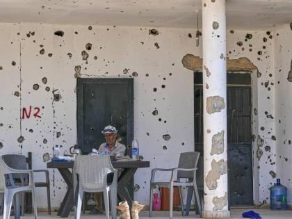 A man sits outside his damaged house in the village of Zawtar al-Gharbieh, south Lebanon.