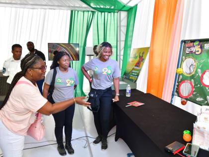 Janique Diamond tries her hand at the interactive ‘Lucky 5’ game at the Evolve booth during the MoBay Jerk and Food Festival. Evolve provided a programme of activities offering festival-goers the chance to play and win prizes throughout the day.