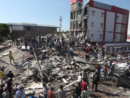 Residents and rescue workers search through the rubble of a collapsed building after an earthquake struck Cali, Colombia, Monday, Aug. 10, 2026. (AP Photo/Santiago Saldarriaga)