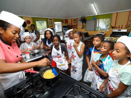 Latoya Panton, chef and founder of the Young Chefs Cooking Club, guides young participants through the preparation of scrambled eggs.