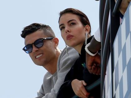 Cristiano Ronaldo (left) and his partner Georgina Rodriguez watch the second practice session at the Monaco racetrack, in Monaco, May 23, 2019. 