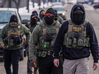 FILE - Federal agents walk down a street while conducting immigration enforcement operations in Minneapolis, Feb. 5, 2026. (AP Photo/Ryan Murphy, File)