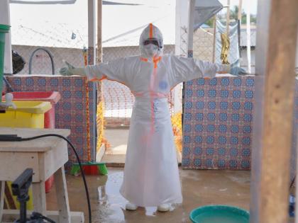 A health worker waits to be sprayed with disinfectant at the treatment centre in Bunia General Hospital in Ituri, eastern Congo, Tuesday.