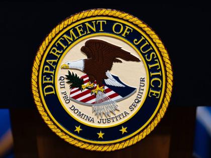 FILE - The U.S. Department of Justice logo is seen on a podium before a news conference, May 4, 2026, in Washington. (AP Photo/Julia Demaree Nikhinson, File)