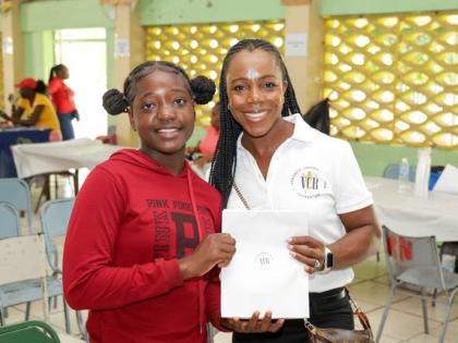 Olympian Veronica Campbell Brown (right) hands over a VCB Foundation gift to a student at last year’s Back-to-School Health and Wellness Fair at Vere Technical High School in Clarendon.