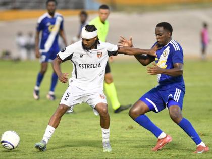 Cebao FC’s Luis Diaz (left), keeps Mount Pleasant Football Academy’s Trayvone Reid during their Caribbean Cup encounter at the National Stadium yesterday. 