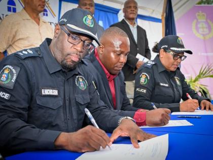 Yian Shettlewood (centre), president of the St John Heights Neighbourhood Watch, signs a memorandum of understanding with Assistant Commissioner of Police Charmaine Shand and Senior Superintendent of Police Hopeton Nicholson, commander of the St Catherine 