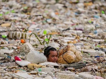A worker uses improvised floats while trying to clear a sea of garbage and debris brought by intense monsoon rains at the Redemptorist Water Channel in Paranaque city, Metro Manila, Philippines, on August 11.