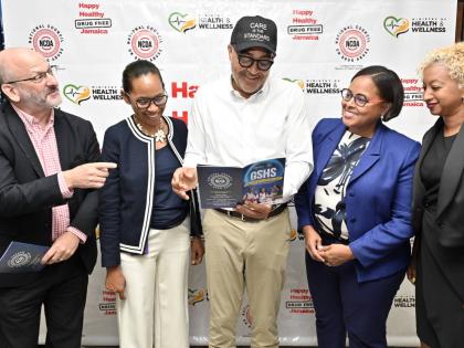 Dr Christopher Tufton (centre), minister of health and wellness, examines the Global School-Based Student Health Survey report while in discussion with (from left) Ian Stein, PAHO/WHO representative to Jamaica, Bermuda and The Cayman Islands; Paulette Smit