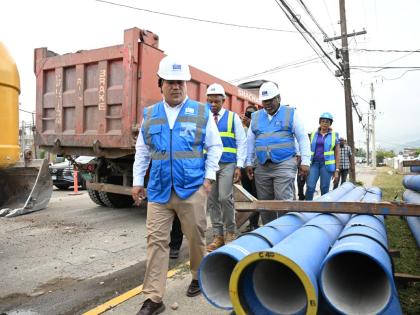 
Minister of Water, Environment and Climate Change, Matthew Samuda (foreground), along with personnel from the National Water Commission (NWC), tours the Monroe Road and Wellington Drive pipeline and sewerage expansion works in St Andrew on September 1.