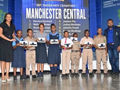 State Minister in the Ministry of Education, Skills, Youth and Information and Member of Parliament for Manchester Central Rhoda Moy Crawford, shares a photo opportunity with students from her constituency as they display tablets received during the Univer