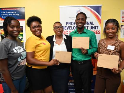 Nordia Barrett-Lewis (centre), founder and chief executive officer of the Atlanta, Georgia-based Barrett Immigration, with the four University of the West Indies students who received $1 million in scholarships that she recently presented to them on August