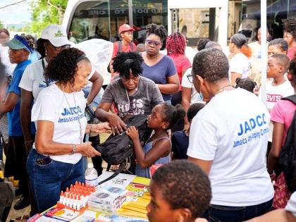 June Spence Jarrett, executive director of the Jamaica Anti-Doping Commission (JADCO), presents a school bag and other school supplies to a child at JADCO’s back-to-school treat held at the Siloah New Testament Church of God in St Elizabeth on August 29.