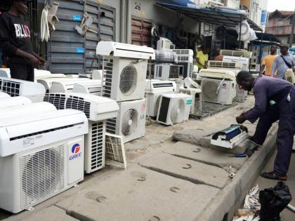 A man repairs air conditioners on the street in Lagos, Nigeria,.