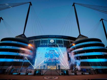 A banner celebrating their title win is illuminated outside Manchester City’s Etihad stadium in Manchester, England, Saturday, May 20, 2023. 