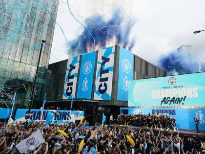 Flares and tape are set off as Manchester City’s players celebrate on stage while fans watch the winners parade as the team celebrates winning the English Premier League title in Manchester, England, Monday, May 23, 2022. 