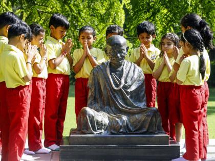 Students pay homage to the statue of Mahatma Gandhi on the eve of Mahatma Gandhi Jayanti observed on October 2 during their visit to the Gandhi Ashram, in the western Indian city of Ahmedabad.