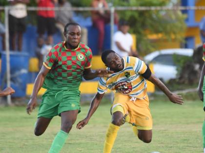 Humble Lion’s Nevar Brooks (left) and  Jhanni Flemmings of Treasure Beach battle for the ball during their Jamaica Premier League match at St Elizabeth Technical High yesterday. The game ended 1-1.