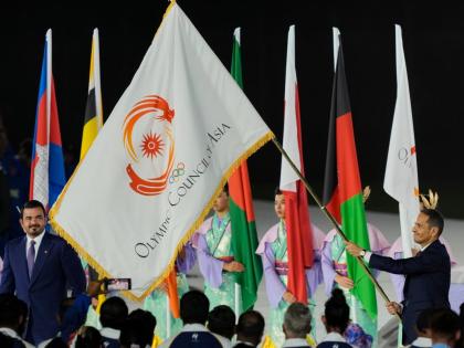 President of the Olympic Council of Asia, Sheikh Joaan Bin Hamad Al Thani (left) looks at the Olympic Council of Asia flag as Sheikh Mohammed bin Abdulrahman Al Thani, Prime Minister of Qatar holds it during the closing ceremony for the Asian Games in Nago