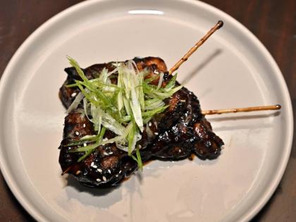 Sesame chicken skewers are marinated in sesame oil and house seasoning, seared and smothered in the house sesame charcoal sauce.