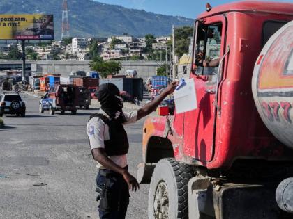 A police officer interacts with a truck driver as he patrols at an intersection in Port-au-Prince, Haiti.