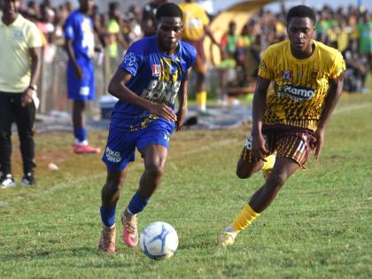 Clarendon College’s Patrick Page (left) tries to outrun Manchester High’s Brandon Brown during  their ISSA Ben Francis KO quarterfinal match at Manchester High’s playing field on Saturday, October 3, 2026.
