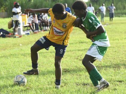 Munro College’s Kajaye Williams (left) shields the ball from Frome Technical High’s Tariq Maxwell during their ISSA Ben Francis Cup knockout tournament second-round match at Frome on September 26.