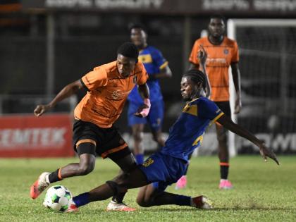 Racing United’s Damion Herrera (right) tackles Tivoli Gardens’ Dwayne Atkinson during a Jamaica Premier League football match at the Waterhouse Stadium yesterday. Racing won the game 4-3.