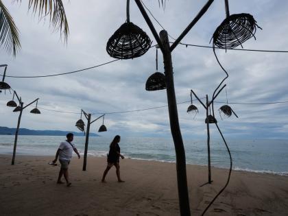 People walk on the beach after the passing of Hurricane Simon in Puerto Vallarta, Mexico, Monday, Oct. 12, 2026. (AP Photo/Fernando Llano)