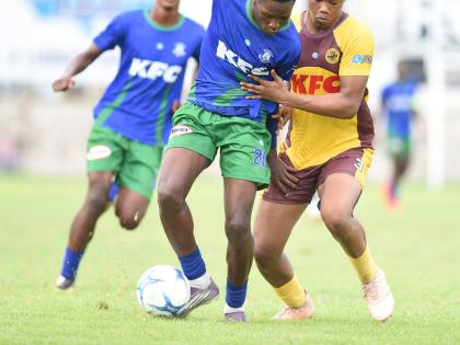Norman Manley High School’s Demarco Bryan (left) and Charlie Smith’s Lashaun Dixon jostle for possession during their Manning Cup football match at the Anthony Spaulding Sports Complex yesterday.
