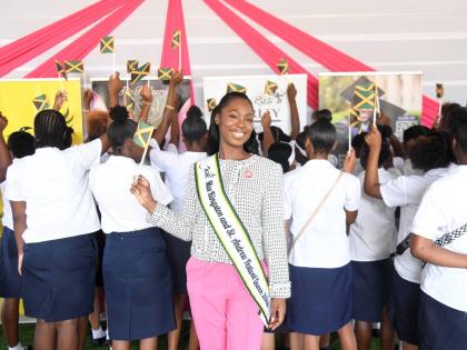 Miss Kingston & St Andrew Danielle Cox waves the Jamaican flag with young moms from the Women’s Centre of Jamaica Foundation at the launch ceremony for her project, The Refinery: Becoming, Not Broken, last Friday at the Louise Bennett Garden Theatre in K