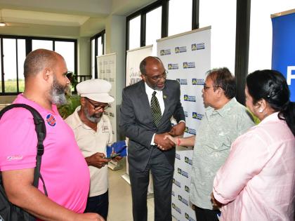 Earl Jarrett (centre), chief executive officer (CEO) of the JN Group, greets Rajan Daswani (second right) and Hansa Daswani (right), owners of Divi Wholesale, during a business luncheon in St Ann, hosted by the JN Group on October 2. Also pictured are Chri