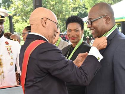 Governor-General Sir Patrick Allen pins the insignia of the Order of Distinction in the Rank of Commander on Professor Densil Williams at the National Honours and Awards Ceremony 2026 at King’s House on Monday. At centre is fellow awardee Audrey Tugwell 