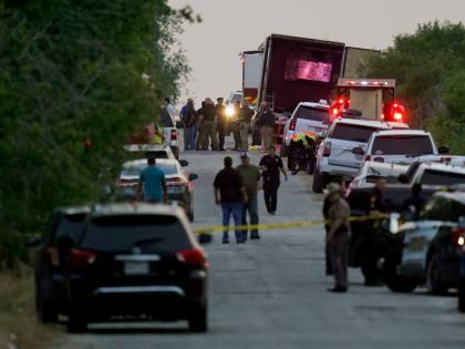 FILE - Police and other first responders work the scene where officials say dozens of people have been found dead and multiple others were taken to hospitals with heat-related illnesses after a tractor-trailer containing suspected migrants was found on Jun