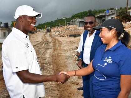 Luwanna Williams, JN Bank managing director, greets Delroy Reid, founder and director of DCR Construction and Development Limited, ahead of a tour of a model unit at Hosanna Estate in Beecher Town, St Ann on October 2. Recordero Setal (second right), sales