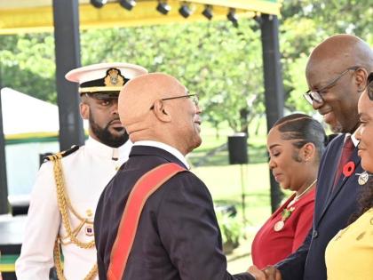 Governor General Sir Patrick Allen (left) congratulates Scean Barnswell (second right) and wife Danielle on their national awards, which he presented to them on Monday. Looking on is fellow awardee Susan Higgins.