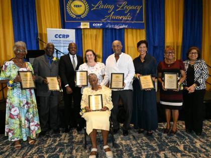 Minister of Labour and Social Security Pearnel Charles Jr. (third left) and Caribbean Community of Retired Persons (CCRP) Founder and Executive Chair,Jean Lowrie-Chin (right), share a moment with the seven recipients of the CCRP 2026 Living Legacy Awards d