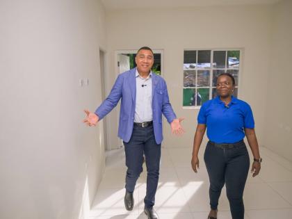 Prime Minister Dr Andrew Holness (left) tours a New Social Housing Programme (NSHP) unit in Greendale district, Bull Bay, with recipient Jodian Bernard on October 21.