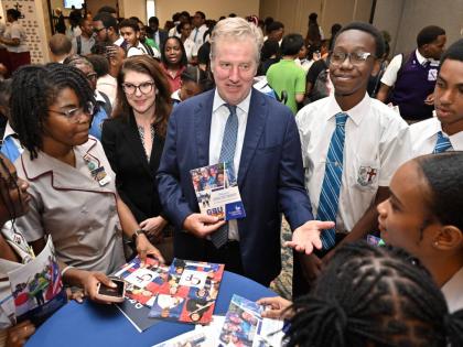 Scott Renner (centre), charge d’affaires at the United States (US) Embassy in Kingston; and Erin Mai Jarrett (third left), public affairs attaché at the embassy, speak with students at the EducationUSA College Fair held yesterday at The Jamaica Pegasus 